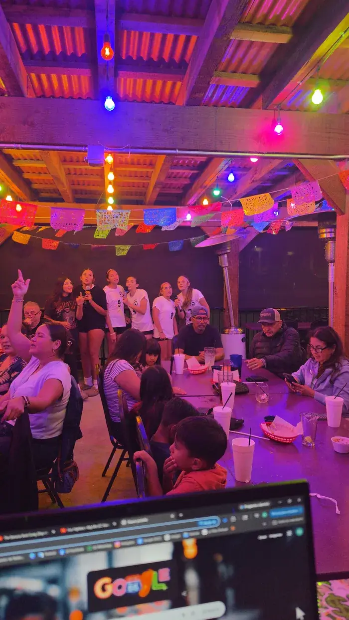 Bar decorado con papel picado y luces de colores durante el karaoke